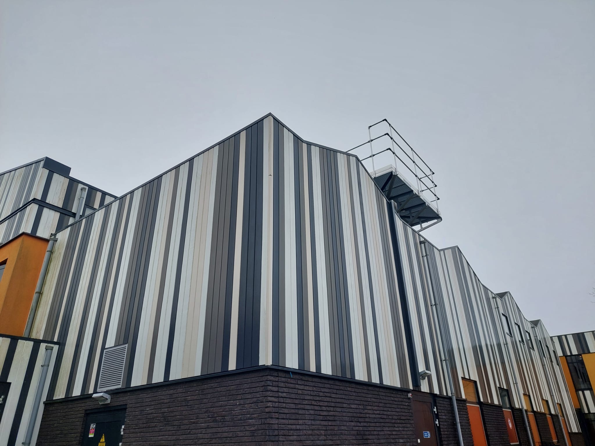 Modern bedrijfspand met verticale gevelbekleding in grijstinten