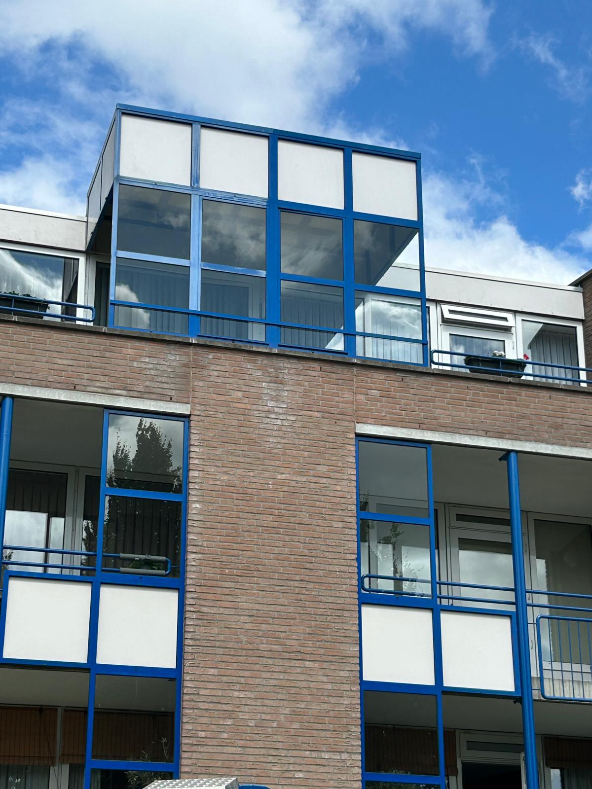 Glaspartijen met blauwe kozijnen na reiniging